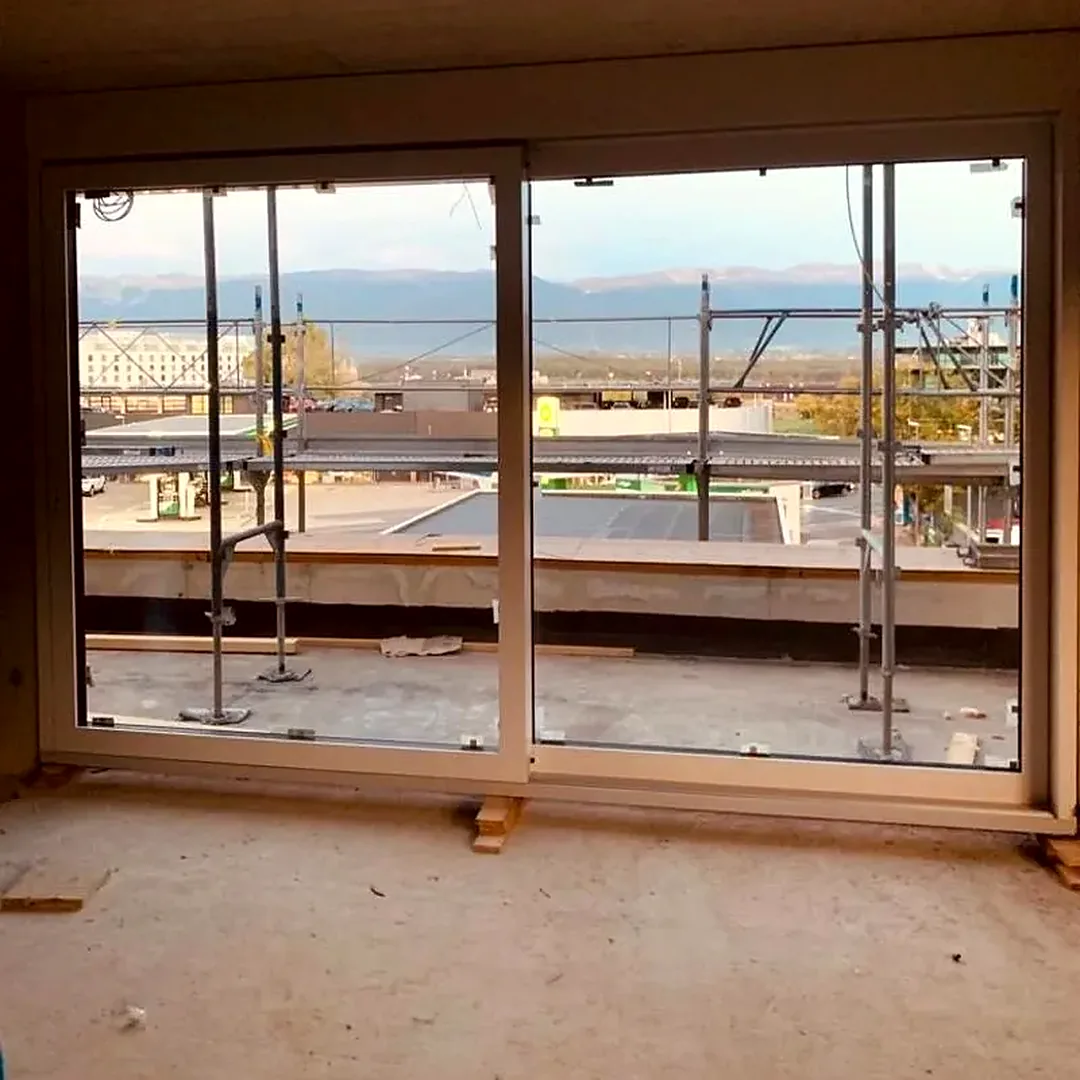 Grande baie vitrée coulissante posée dans un immeuble neuf à Genève